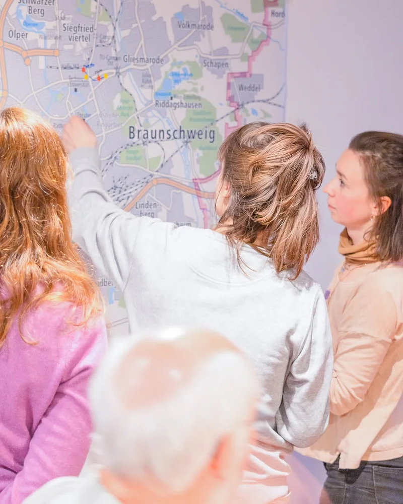 Flyer displaying 'SP00N INFORMATIONEN' text with colorful graphics on a wooden surface.